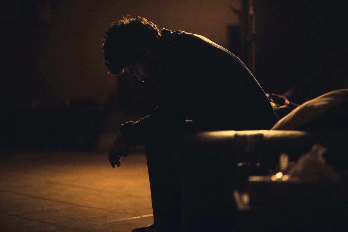 Man sitting in the dark feeling depressed and emotionally drained