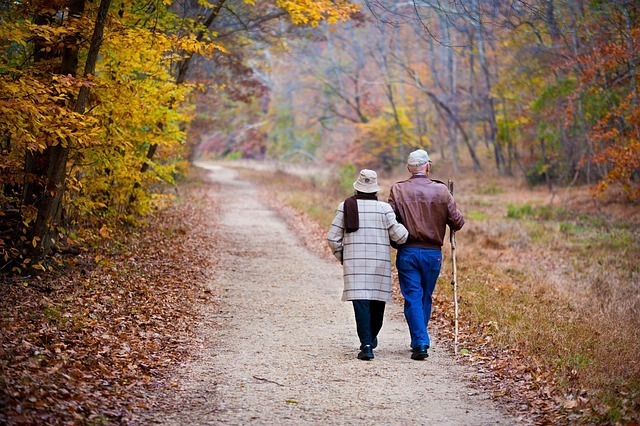 elder couple walking together in a trail in Ottawa Ontario symbolizing love and long lasting relationships